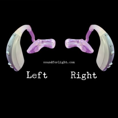 Two identical BTE hearing aids with gray body and purple molds set up in a mirror image. Set on black background, with white labels underneath: left and right.