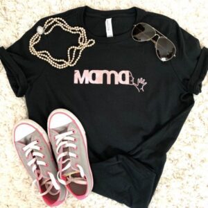 Black t shirt with pink foil decal spelling MAMA with the ASL sign emerging from the last letter A. Shirt is arranged on an off white shag rug with grey and pink converse shoes, aviator sunglasses and a double strand of pearls on top.